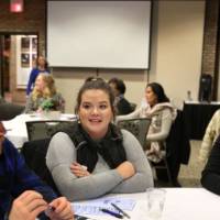 Three students practice civil discourse at their table
